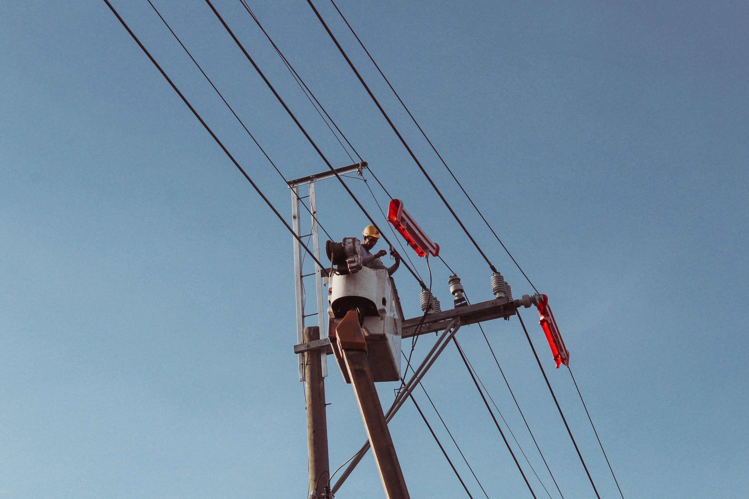 Engineer works on high power lines, ensuring electrical safety and maintenance.
